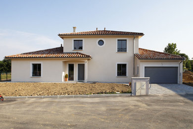 Aménagement d'une façade de maison beige classique à un étage.