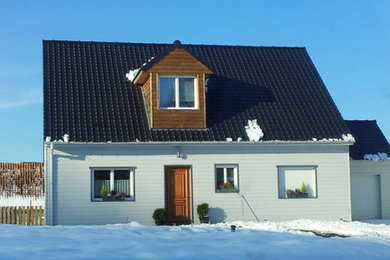 Cette photo montre une grande façade de maison blanche chic en bois à un étage avec un toit à deux pans et un toit en tuile.