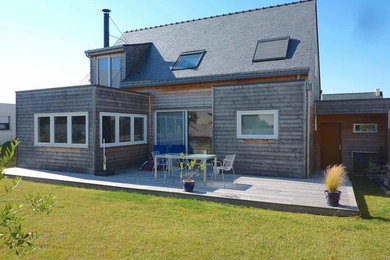 Cette image montre une façade de maison design en bois avec un toit à deux pans.