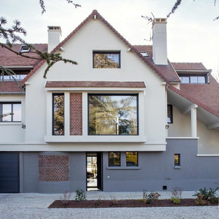 Réalisation d'une grand façade en brique beige design à deux étages et plus avec un toit à deux pans.