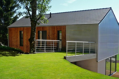 Exemple d'une façade de maison tendance avec un revêtement mixte et un toit à deux pans.