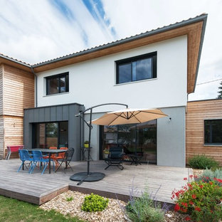 Inspiration pour une façade de maison double multicolore design à un étage avec un revêtement mixte, un toit plat et un toit en tuile.