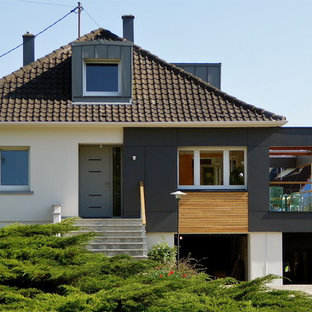 Exemple d'une façade de maison multicolore tendance à un étage avec un revêtement mixte, un toit à quatre pans et un toit en tuile.