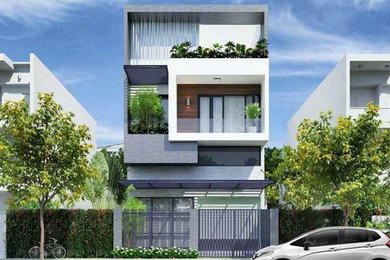 Inspiration pour une façade de maison de ville grise design de taille moyenne et à deux étages et plus avec un revêtement mixte, un toit plat et un toit mixte.