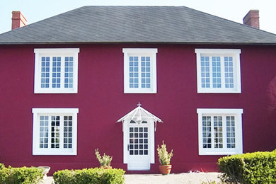 Inspiration pour une façade de maison rouge traditionnelle de taille moyenne et à un étage.
