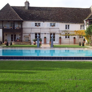 Aménagement d'une grand façade de maison beige campagne à un étage avec un toit à deux pans.