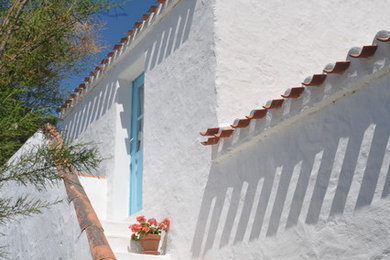 Inspiration pour une façade de maison blanche méditerranéenne de taille moyenne et à un étage avec un toit plat.