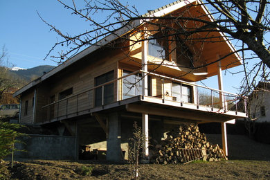 Idées déco pour une grande façade de maison beige montagne en bois à deux étages et plus avec un toit de Gambrel et un toit en tuile.