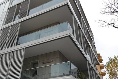 Ejemplo de fachada gris clásica renovada grande de tres plantas con revestimientos combinados y tejado plano
