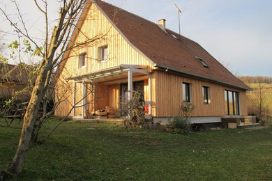Cette photo montre une façade de maison nature en bois avec un toit à deux pans.