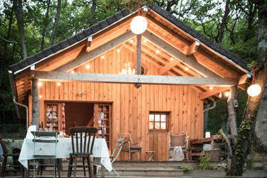 Cette photo montre une petite façade de Tiny House nature en bois à un étage avec un toit à deux pans et un toit noir.