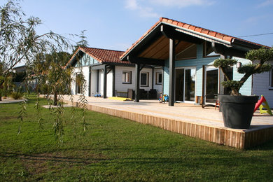 Cette photo montre une façade de maison bleue tendance en bois de plain-pied et de taille moyenne avec un toit à deux pans.
