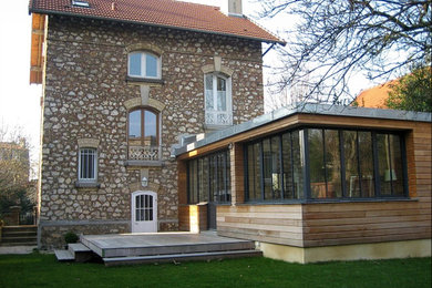 Exemple d'une grande façade de maison grise nature en pierre à deux étages et plus avec un toit à deux pans et un toit en tuile.