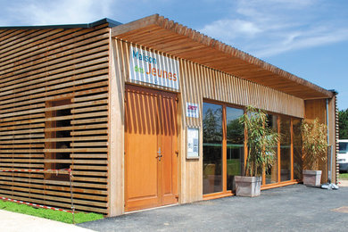 Idée de décoration pour une petite façade de maison en bois de plain-pied avec un toit plat.