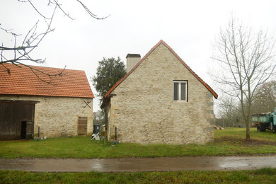 Diseño de fachada de casa beige de estilo de casa de campo de dos plantas con revestimiento de piedra, tejado a dos aguas y tejado de teja de barro