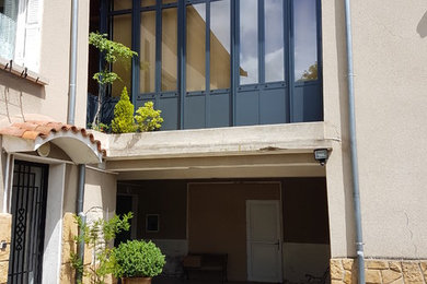 Idée de décoration pour une grande façade de maison de ville métallique et beige urbaine à un étage.