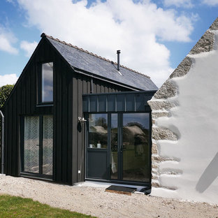 Cette photo montre une façade de maison noire tendance à un étage avec un revêtement mixte et un toit à deux pans.