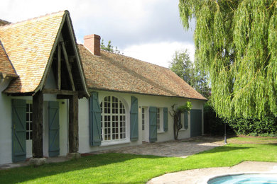 Foto de fachada de casa blanca contemporánea de dos plantas con revestimiento de adobe, tejado a dos aguas y tejado de teja de barro