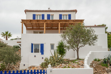 Diseño de fachada de casa blanca marinera de tres plantas con tejado a cuatro aguas y tejado de teja de barro