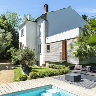 Idées déco pour une façade de maison multicolore méditerranéenne avec un revêtement mixte, un toit à deux pans et un toit en tuile.