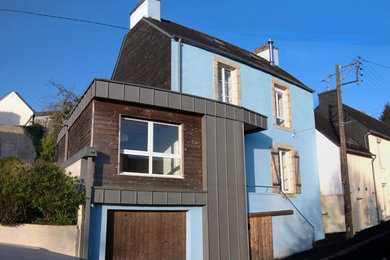 Cette image montre une petite façade de maison de ville métallique et multicolore design à un étage avec un toit plat et un toit mixte.