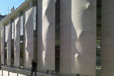Idée de décoration pour une façade de maison grise minimaliste en pierre de taille moyenne.