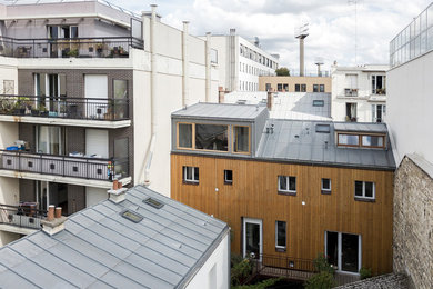 Idée de décoration pour un façade d'immeuble métallique design avec un toit à deux pans et un toit en métal.