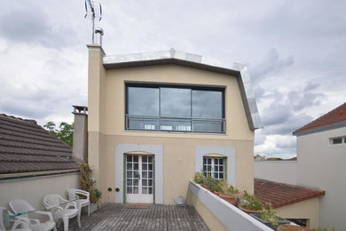 Imagen de fachada de casa beige moderna de tamaño medio de tres plantas con tejado de metal y tejado a doble faldón