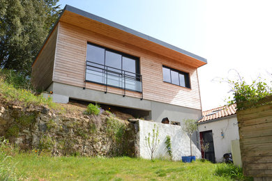 Imagen de fachada marrón contemporánea de tamaño medio de tres plantas con revestimiento de madera y tejado plano