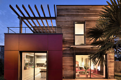 Idee per la facciata di una casa rossa contemporanea a due piani con rivestimenti misti e tetto piano