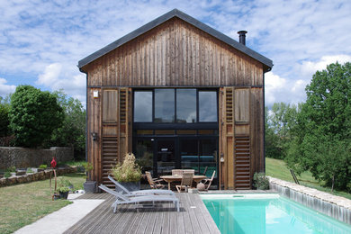 Ejemplo de fachada marrón de estilo de casa de campo de dos plantas con revestimiento de madera y tejado a dos aguas