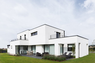 Inspiration pour une façade de maison blanche design de taille moyenne et à un étage avec un toit plat.