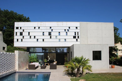 Idées déco pour une façade de maison grise contemporaine en béton de taille moyenne avec un toit plat.