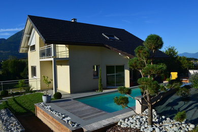 This is an example of a large and beige contemporary two floor detached house in Grenoble.