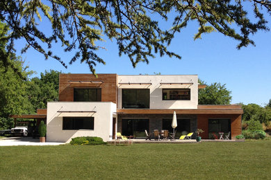 Idée de décoration pour une façade de maison blanche design de taille moyenne et à un étage avec un revêtement mixte, un toit plat et un toit végétal.