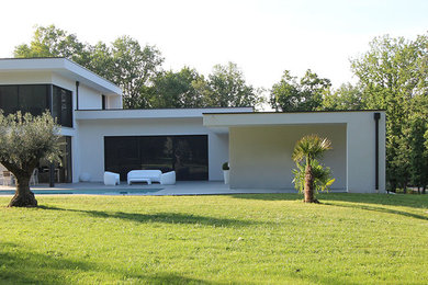 Diseño de fachada de casa blanca contemporánea grande de dos plantas con revestimiento de hormigón y tejado plano