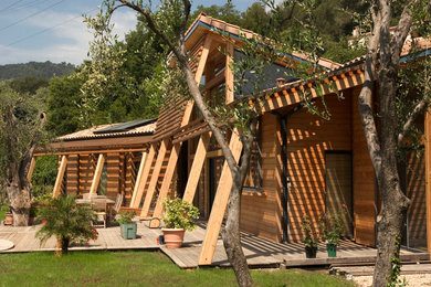 Aménagement d'une façade de maison marron contemporaine en bois de taille moyenne et à un étage avec un toit à deux pans.