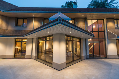 Cette image montre une très grande façade de maison blanche design en bois à un étage avec un toit à deux pans.