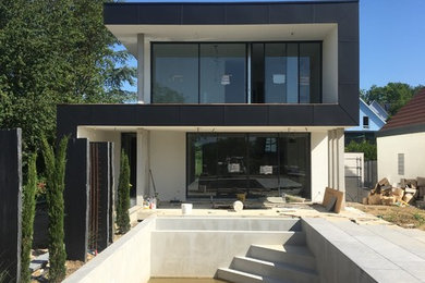 Inspiration pour une façade de maison minimaliste de taille moyenne et à deux étages et plus avec un toit plat.