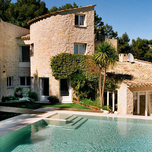 Exemple d'une façade en pierre beige méditerranéenne de taille moyenne et à deux étages et plus avec un toit en appentis.