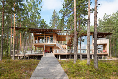 Modelo de fachada de casa marrón nórdica grande de dos plantas con revestimiento de madera, tejado plano y techo verde