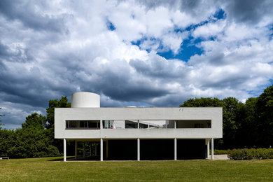 Modelo de fachada gris minimalista de tres plantas con revestimiento de hormigón y tejado plano