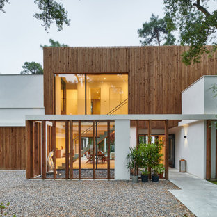 Inspiration pour une grand façade de maison multicolore design à un étage avec un revêtement mixte et un toit plat.