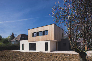 Aménagement d'une façade de maison blanche contemporaine en bois de taille moyenne et à un étage avec un toit plat.
