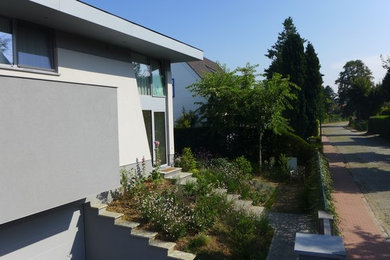 Cette image montre une grande façade de maison grise design à deux étages et plus avec un revêtement mixte et un toit à deux pans.