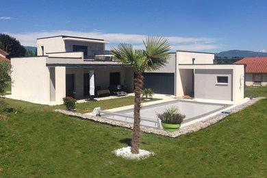 Photo of a medium sized and beige split-level detached house in Lyon with a flat roof.