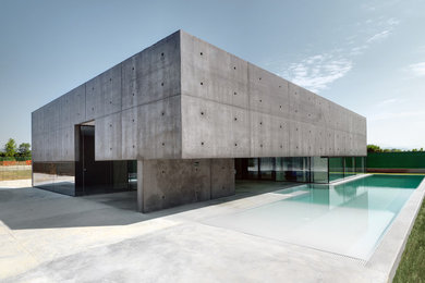 Imagen de fachada gris minimalista extra grande de dos plantas con revestimiento de aglomerado de cemento y tejado plano