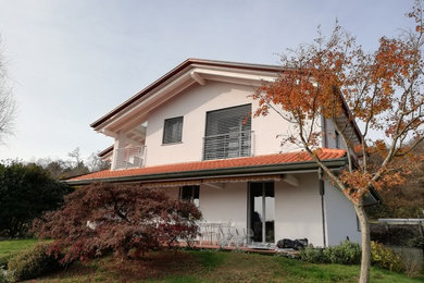 Foto de fachada de casa blanca tradicional de tamaño medio de dos plantas con revestimiento de estuco, tejado a doble faldón y tejado de teja de barro