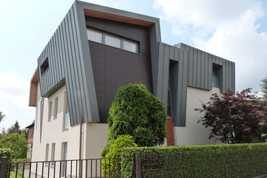 Esempio della facciata di una casa bifamiliare piccola grigia contemporanea a tre piani con rivestimento in metallo, tetto a mansarda e copertura in metallo o lamiera