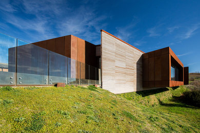 Immagine della facciata di una casa marrone contemporanea a due piani di medie dimensioni con rivestimento in legno, tetto piano e copertura mista